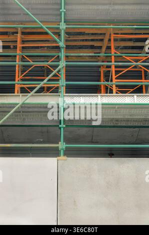 Détail graphique de l'échafaudage et du mur de béton d'un bâtiment de plusieurs étages en construction Banque D'Images