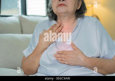 La maladie de reflux acide, souffrir la femme âgée asiatique ont des symptômes gastro-œsophagien, œsophagien, mal d'estomac et douleur de brûlure d'estomac main sur la poitrine de la digestion p Banque D'Images