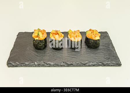 Vue centrale d'un repas qui comprend une généreuse portion de saumon frais, une généreuse quantité de riz et une sélection de sushis assortis sur le côté Banque D'Images