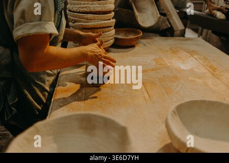 Les mains dans la farine de la pâte à pétrir gros plan sur table Banque D'Images