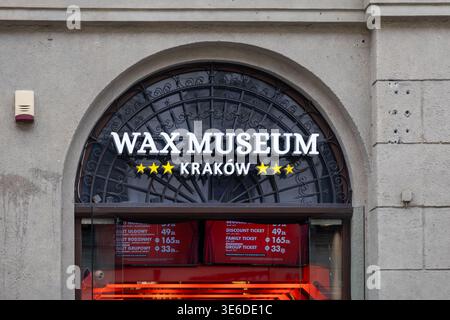 Cracovie, Pologne - 1er décembre 2025 : vue de face du panneau du Musée de cire de Cracovie, affichant un texte illuminé et des étoiles au-dessus de l'entrée voûtée, un captiv Banque D'Images