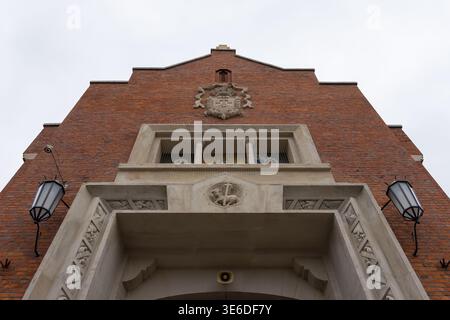 Cracovie, Pologne - 1er décembre 2025 : vue architecturale à angle bas d'un ancien bâtiment en briques, mettant en évidence sa façade détaillée, son agneau religieux et sa croix c. Banque D'Images