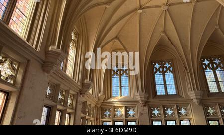 Grande salle gothique avec de hautes fenêtres à plafond voûté et des colonnes de pierre à l'intérieur du château Malbork en Pologne. Architecture, patrimoine et espace intérieur con Banque D'Images