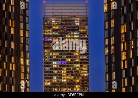 Trois grandes tours d'appartements résidentiels dans le centre-ville de Manchester à l'heure bleue, avec des fenêtres éclairées créant une grille de lumière chaude. Banque D'Images