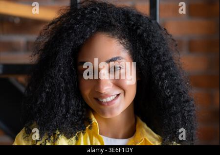 Souriant positive jeune femme brune regardant heureuse Banque D'Images