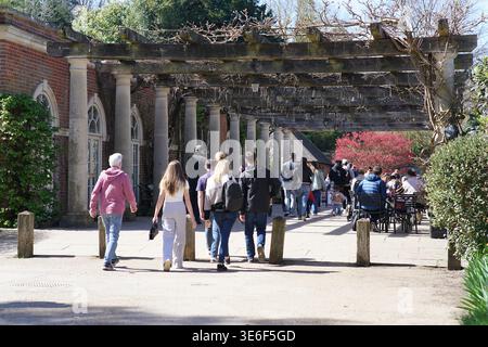 Les visiteurs se promènent sous la longue pergola en pierre des jardins du château de Hever lors d'une journée de printemps ensoleillée dans le Kent, en Angleterre. Château de Hever, Hever, Angleterre Banque D'Images