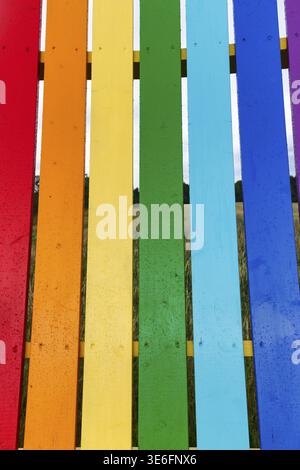 Lattes verticales en bois en rouge, orange, jaune, vert, bleu clair, bleu foncé et violet, dossier, meubles de jardin aux couleurs arc-en-ciel, Gotland, Suède Banque D'Images