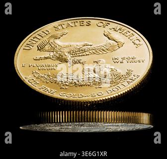 Close up of a solid gold eagle one ounce coin reflète dans surface brillante noire Banque D'Images
