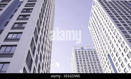 Vue de dessous des bâtiments résidentiels avec ciel bleu. Cadre. Vue de dessous de la façade de la maison moderne à plusieurs étages Banque D'Images