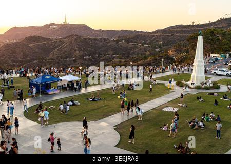Vue aérienne de la pelouse de l'Observatoire Griffith au coucher du soleil, parc public de Los Angeles avec obélisque du Monument des astronomes et le panneau Hollywood à distance Banque D'Images