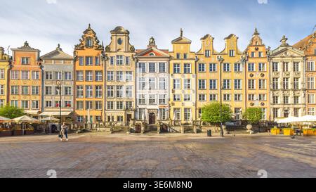 Gdansk, Pologne - 2 mai 2025 : la place du long marché. Des bâtiments historiques colorés bordent une place pavée dans une ville européenne. Une personne traverse Banque D'Images