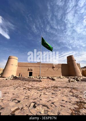 Vue panoramique de jour sur la forteresse Al Masmak à Riyad, en Arabie Saoudite, avec le drapeau saoudien flottant au-dessus du site historique. Banque D'Images