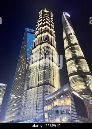 Vue nocturne en angle bas de la tour de Shanghai et des gratte-ciel voisins à Pudong, Shanghai, Chine. Banque D'Images