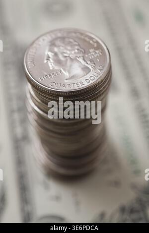 Gros plan d'une grande pile de pièces d'un quart de dollar américain ou de vingt-cinq cents sur le fond d'un billet d'un dollar, Studio composition, Québec, Canada Banque D'Images