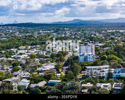 Une vue surélevée capture le paysage résidentiel tentaculaire de Sunshine Coast, Queensland, avec des arbres luxuriants et les Glass House Mountains dans le dist Banque D'Images