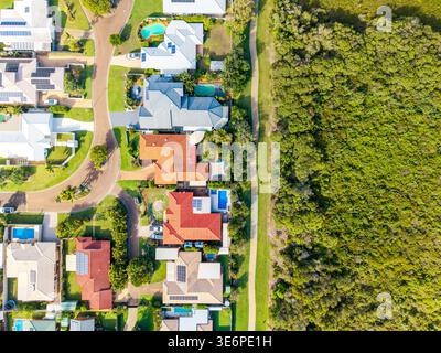 Une perspective aérienne capture une communauté de banlieue dynamique avec de nombreuses maisons, beaucoup avec des panneaux solaires et des piscines, adjacentes à Extensiv Banque D'Images