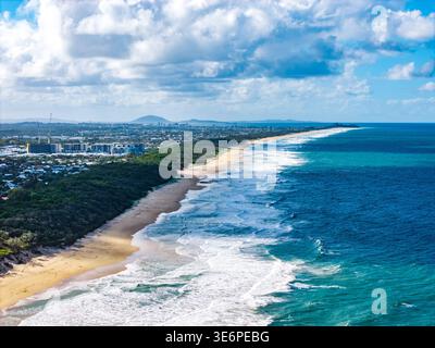 Une vaste prise de vue aérienne capture la côte animée de Sunshine Coast, Queensland, avec ses plages de sable, ses vagues qui s'écrasent et son développement urbain. Banque D'Images