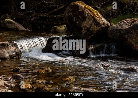 Vue rapprochée d'une petite cascade coulant sur de grosses pierres dans une rivière à Swaledale Banque D'Images
