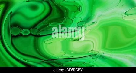Liquide vert abstrait avec des bulles d'huile créant des motifs fluides et des tourbillons Banque D'Images