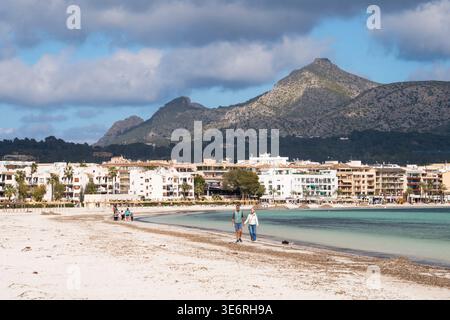 Un couple marchant le long du rivage à la Playa de Alcúdia à Port d'Alcúdia, Majorque, Espagne Banque D'Images