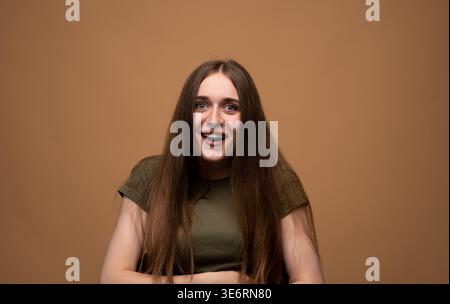 Jeune femme se sentant surprise et heureuse, exprimant l'excitation et les émotions positives avec les yeux larges et la bouche ouverte Banque D'Images