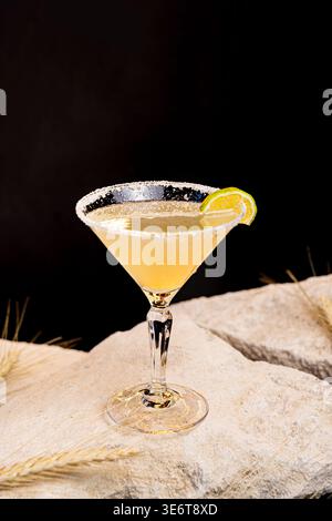 Cocktail Margarita dans les verres classiques, vue de côté sur un fond noir, avec de la glace. Boissons d'été avec citron vert et un bord de sel, avec espace de copie Banque D'Images