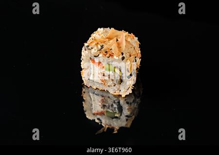 Deux rouleaux de sushi recouverts de flocons de poisson de bonite et de graines de sésame noir, avec anguille grillée, fromage à la crème, avocat et garniture de caviar tobiko rouge, isolez Banque D'Images