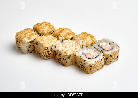 Huit rouleaux de sushi cuits au four recouverts d'un mélange de graines de sésame noir et blanc et d'une garniture de fromage cuit doré, avec chair de crabe et garniture de fromage à la crème, un Banque D'Images