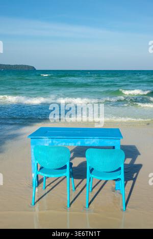 Table bleue avec deux chaises sur la plage dans l'eau, bar en bord de mer et restaurant sur l'île de Koh Rong Sanloem, Cambodge Banque D'Images