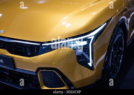 Zurich, Suisse, 10 octobre 2025. Gros plan du phare LED futuriste et de la calandre avant de la nouvelle Kia K4 GT-Line en jaune exposé au Banque D'Images