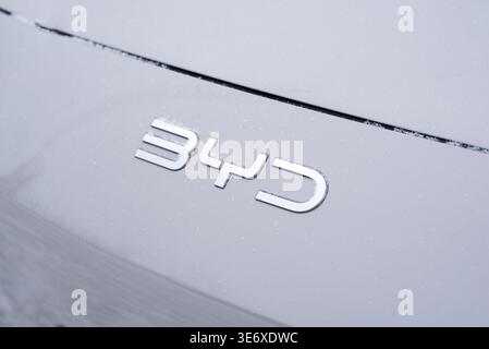 Kiev, Ukraine. 31 janvier 2026. Logo BYD chromé argenté sur un capot de voiture électrique blanc recouvert de neige légère. Gros plan minimaliste. Banque D'Images