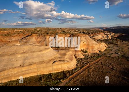 Vue aérienne des collines colorées de grès rayé et paysage désertique dans les badlands de l'Utah sous des nuages spectaculaires, États-Unis. Banque D'Images