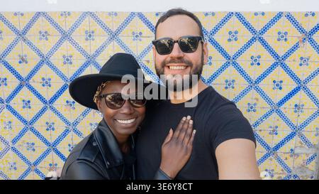 Heureux couple interracial prenant Selfie par Historic Azulejo Tile Wall au Portugal Banque D'Images