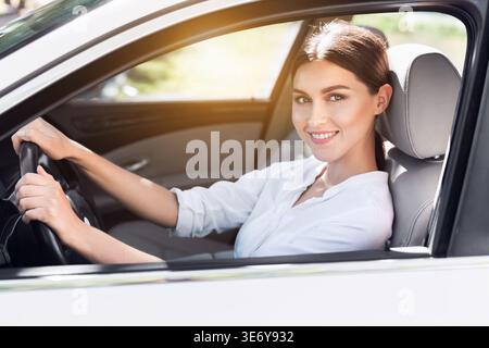 Jeune femme d'affaires assise dans sa voiture Banque D'Images
