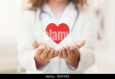 Médecin cardiologue tenant le coeur virtuel entre les mains Banque D'Images