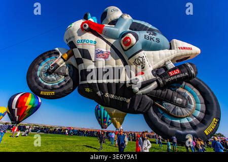 Albuquerque, États-Unis - 09 octobre 2017 : vue d'une montgolfière en forme de moto survolant le champ vert vibrant, un spectacle de c Banque D'Images