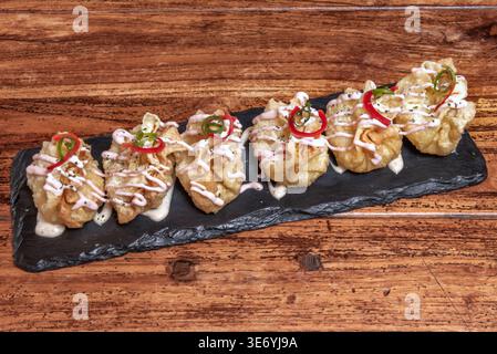 Wontons péruviens fraîchement frits avec leur garniture signature de porc haché, d'oignons verts et d'épices, présentés comme petits, dorés, et des boulettes croustillantes Banque D'Images