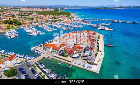 Tribunj, Croatie. Vue aérienne drone de la vieille ville et de la marina pleine de bateaux. Banque D'Images