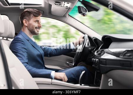 Homme élégant dans la voiture de conduite de costume d'affaires Banque D'Images