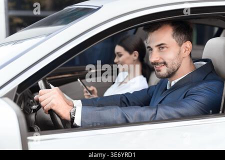 Couple d'affaires assis sur les sièges passagers avant Banque D'Images