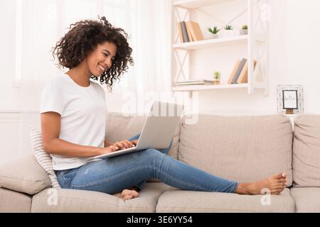 Femme afro-américaine travaillant sur ordinateur portable à la maison Banque D'Images