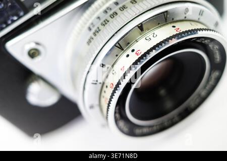 Gros plan d'un objectif d'appareil photo vintage montrant des détails complexes. L'objectif comporte des anneaux métalliques avec des numéros gravés pour le réglage de l'ouverture et de la mise au point. T Banque D'Images