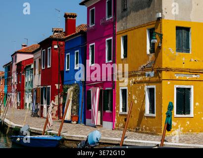 Burano, Italie - 25 juin 2025 : les maisons vibrantes le long du canal à Burano, Italie, se reflètent magnifiquement sur l'eau, créant une atmosphère visuelle époustouflante Banque D'Images