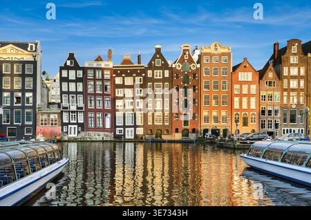Bâtiments historiques sur le canal Damrak à Amsterdam, pays-Bas par une journée ensoleillée Banque D'Images