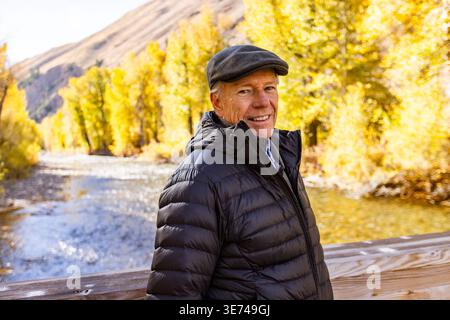 USA, Idaho, Bellevue, Portrait de femme blonde senior à la rivière en automne Banque D'Images