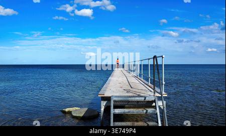 Gudhjem, Danemark 19-08-2017 Description : homme debout au bout d'une jetée en bois surplombant la mer Baltique, Melsted. Banque D'Images