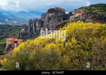 Vue panoramique sur les formations rocheuses et les monastères des Météores depuis le point de vue principal en Grèce sous les nuages de tempête dramatiques. Puits de pluie visibles et atmos Banque D'Images