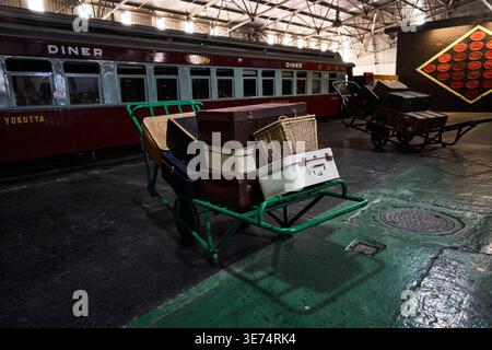 Vieux chariot à bagages dans le dépôt. Cadre industriel calme avec troncs vintage et fond de train Banque D'Images