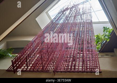 Vue en contre-plongé d'une installation artistique contemporaine à grande échelle suspendue à une lucarne dans un espace architectural intérieur. L'œuvre d'art se compose de Banque D'Images