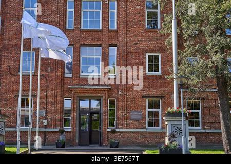 L'image représente la façade d'un bâtiment institutionnel en briques rouges à plusieurs étages présentant une architecture symétrique avec des rectangles encadrés de blanc Banque D'Images